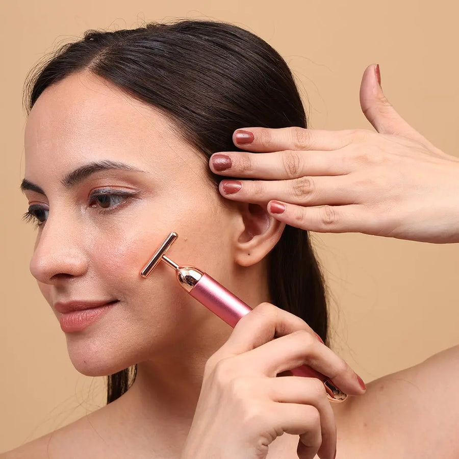Woman using rose gold facial roller for glowing skin care routine